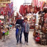 coppia di turisti in posa in mezzo ad un mercatino