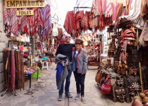 coppia di turisti in posa in mezzo ad un mercatino