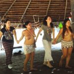 locali e turisti danzano in cerchio