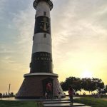 faro marino con tramonto sullo sfondo