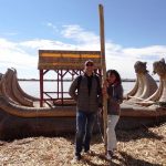 coppia di turisti in posa davanti a imbarcazione fatta a mano