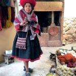 ragazza in abiti tipici peruviani mostra la lana di alpaca